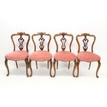 Set of four Victorian carved walnut salon chairs, each with pierced vertical splat,