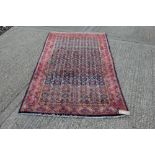 Persian Malayer rug with allover foliate motif on aubergine ground in borders,