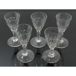 Four Georgian port glasses with slice-cut bowls and facet cut stems on splayed foot, 11.