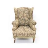 19th century wing armchair raised on turned wooden legs and castors