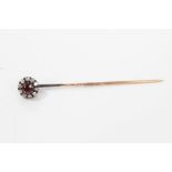 Victorian ruby and diamond cluster stick pin with a central mixed cut ruby surrounded by old cut