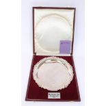 Contemporary silver salver of circular form, with dished centre and shell and foliate border,