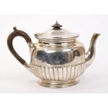 Victorian silver teapot of half-fluted circular form, with engraved armorial crest,