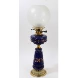 Late 19th / early 20th century oil lamp with etched globular shade and floral painted blue glass
