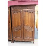 19th century French carved chestnut armoire enclosed by a pair of floral carved rectangular panel