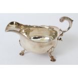 George II silver sauce boat of conventional form, with wavy rim and open scroll handle,