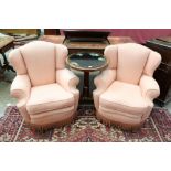 Pair of deep upholstered easy chairs each with arched back, overscroll arms on castors,