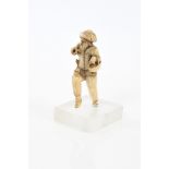 Early German carved ivory figure in prancing pose, a basket on his arm and sword at his waist,