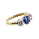 Sapphire and diamond three stone ring with an oval mixed cut blue sapphire flanked by two brilliant