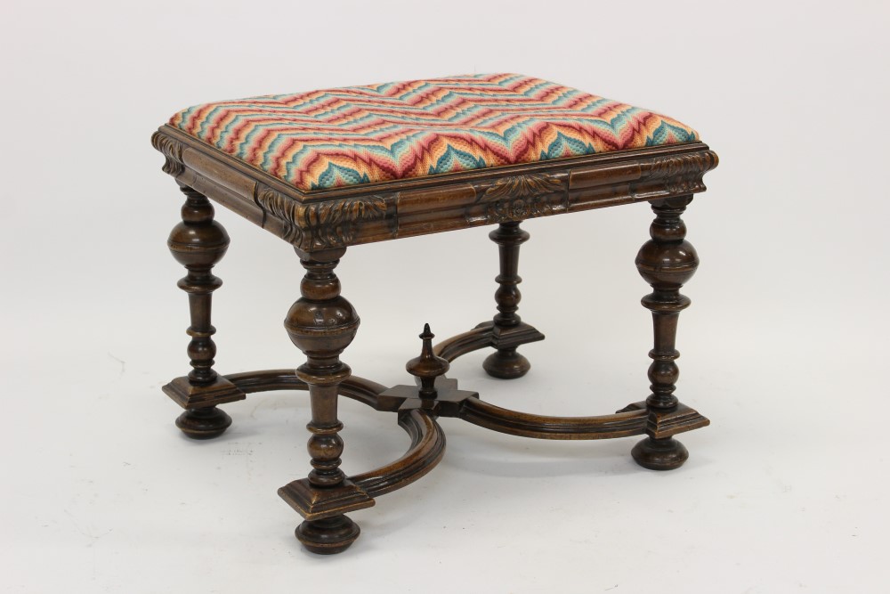 Carolean-style carved walnut stool with striped upholstered slip-in seat on leaf carved frieze and