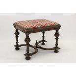 Carolean-style carved walnut stool with striped upholstered slip-in seat on leaf carved frieze and