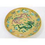 Chinese yellow porcelain dish with incised five-clawed dragons chasing a flaming pearl amid clouds