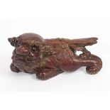 19th / early 20th century Chinese carved and red lacquered wooden figure of a temple dog,