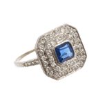 Sapphire and diamond cluster ring with a central step cut blue sapphire surrounded by a double