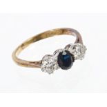 Sapphire and diamond three stone ring with a central oval mixed cut blue sapphire flanked by a