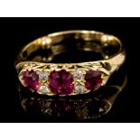 Late Victorian ruby and diamond ring with three oval mixed cut rubies interspaced by four old cut