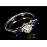 Diamond and sapphire three stone ring with a brilliant cut diamond estimated to weigh approximately