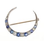 Edwardian diamond and sapphire crescent brooch with graduated oval mixed cut blue sapphires