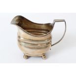 George III silver cream jug of bellied form, with reeded rim, angular silver handle,