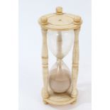 19th century carved ivory hourglass of typical form, the blown glass between disc supports,