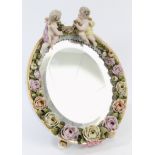 Late 19th century Dresden porcelain oval framed mirror with cherub mounts and floral encrusted