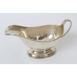 George V silver sauce boat with reeded border and loop handle,