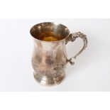 Large 19th century white metal mug of baluster form, with embossed foliate decoration,