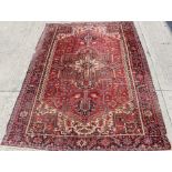 Old Heriz carpet with central medallion and foliate branch work on brick-red ground,