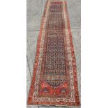Old Persian runner with repeating floral medallions on blue, red and cream ground, 503cm x 103cm,