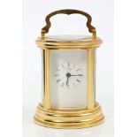 Contemporary gilt brass carriage clock in oval-form case, with white enamel dial,