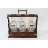 Late 19th / early 20th century oak and silver plate mounted tantalus with three squared cut glass