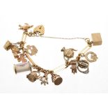 9ct gold charm bracelet with a collection of 9ct gold and yellow metal novelty charms