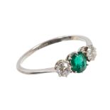 Emerald and diamond three stone ring with an oval mixed cut emerald flanked by two old cut diamonds