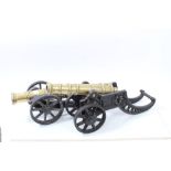 Two 19th century brass barreled model cannons on cast iron carriages,