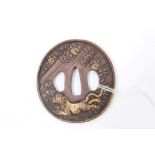 Japanese Edo period bronze tsuba of circular form decorated in relief with tiger and dragon