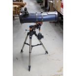 A Celestran Astromaster 130 telescope mounted on a telescopic and fully-adjustable tripod