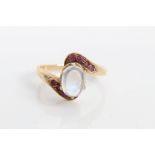 Moonstone oval cabochon crossover ring with four mixed cut rubies set to each shoulder,