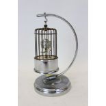 German novelty clock in the form of a bird in a cage suspended from a moon-shaped stand