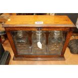 Late Victorian oak tantalus cabinet with bevelled glazed front enclosing three cut glass spirit