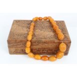 Vintage amber necklace consisting of a string of amber beads with several simulated amber beads,