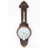 Aneroid wheel barometer with 8 inch dial and separate thermometer in a carved oak case