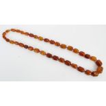 Amber graduated bead necklace with thirty-seven polished oblong beads,