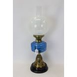 Early 20th century brass oil lamp with opalescent globular shade and blue glass reservoir,