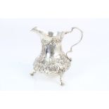 Victorian silver cream jug of baluster form, with later chased floral decoration and scroll handle,