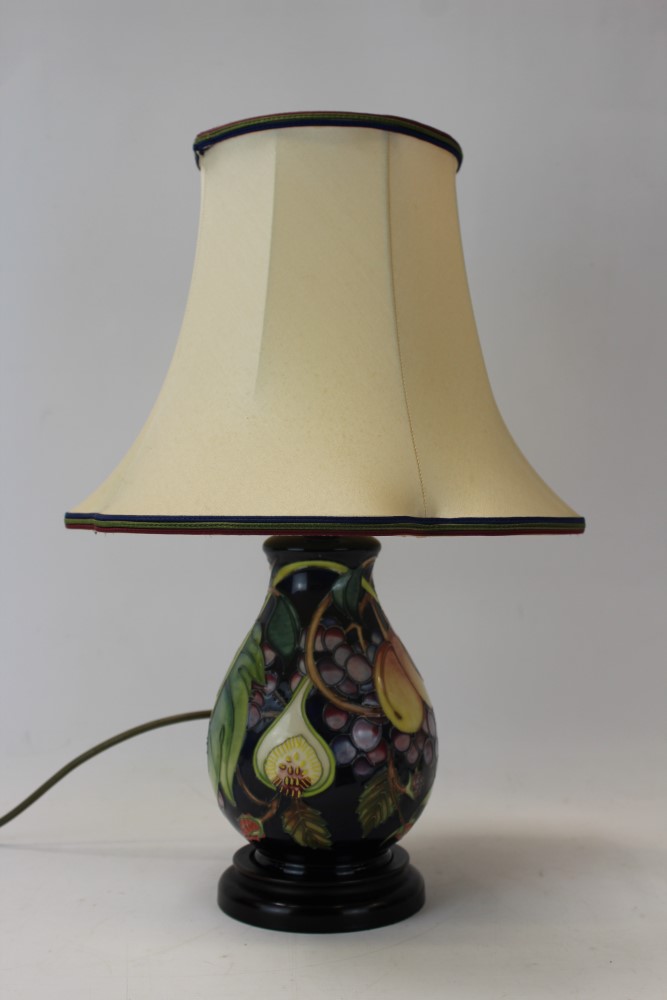 Moorcroft pottery table lamp decorated in the Queens Choice pattern on blue ground,