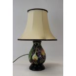 Moorcroft pottery table lamp decorated in the Queens Choice pattern on blue ground,