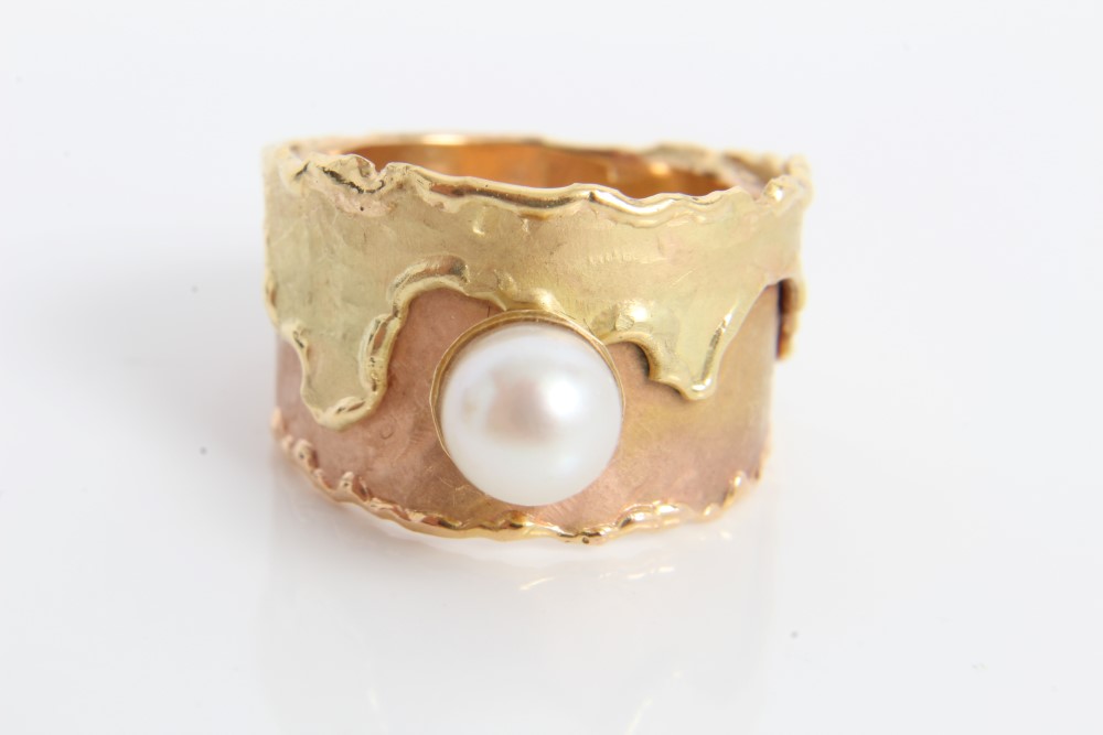 Two-colour yellow metal wide band ring set with a single cultured pearl.