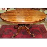 Mid 19th century rosewood loo table the well-figured oval tilt-top on lobed column and carved