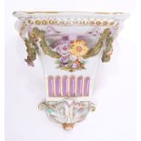 Late 19th century German porcelain wall bracket with painted figures and floral swag decoration,