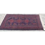 Pakistani rug, aubergine ground with three conjoined lozenge medallions in mihrab borders,